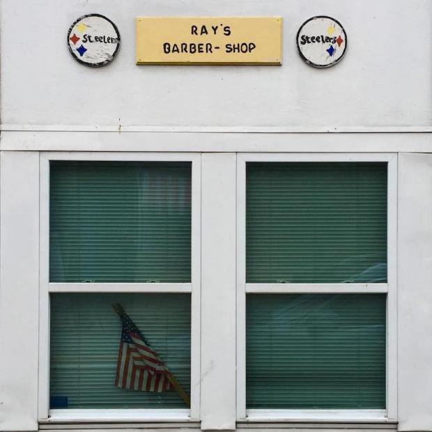 exterior of Ray's Barber Shop, Pittsburgh, with two homemade Steelers emblems