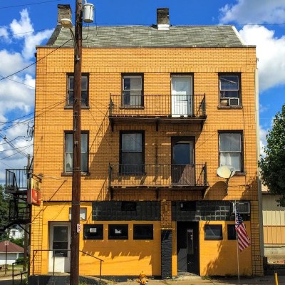 brick building with first floor bar exterior painted black and gold, Brownsville, PA
