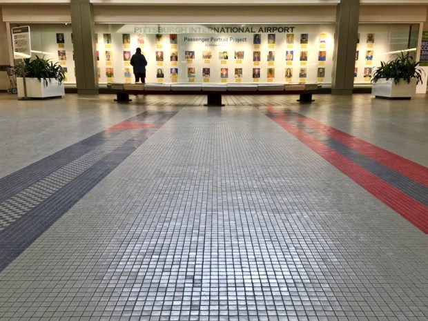 Passenger Portrait Project installed in glass case at Pittsburgh International Airport