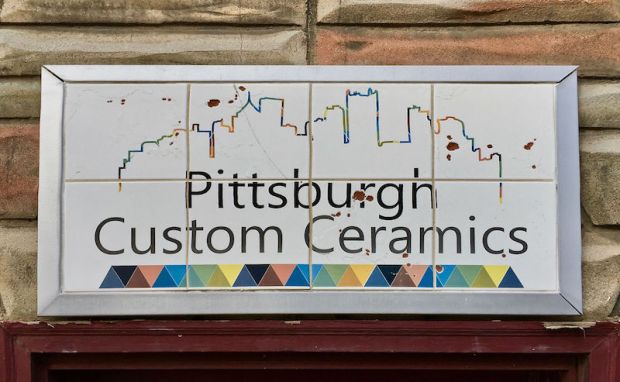 retail store sign for Pittsburgh Custom Ceramics with outline of Pittsburgh's skyline