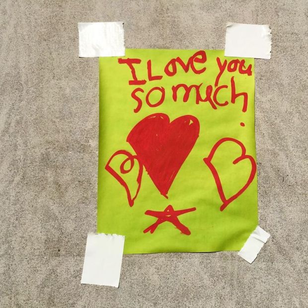 message taped to wall reading "I love you so much"