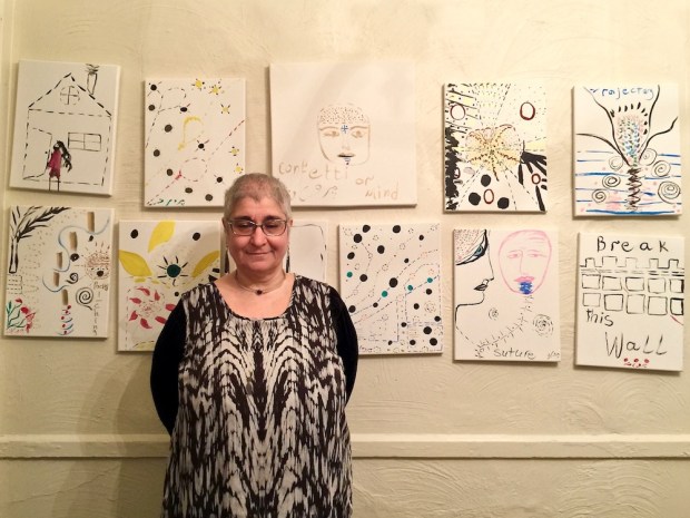 artist Parvaneh Torkamani with wall of paintings