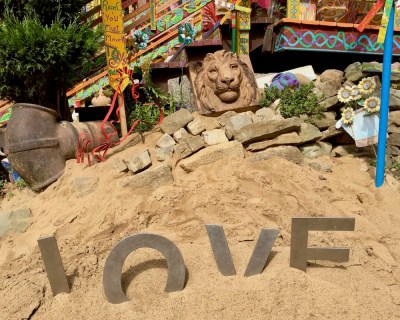 metal letters spelling L-O-V-E in sand at Randyland