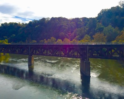 river, trees in fall colors, and train bridge in Western PA