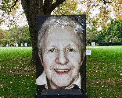 large portrait of Holocaust survivor mounted on exterior display at the University of Pittsburgh campus as part of Luigi Toscano's "Lest We Forget" portrait series