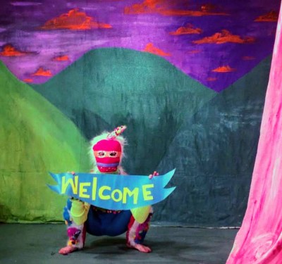 costumed character with "Welcome" sign