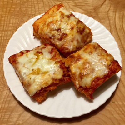 three rectangular slices of pizza on a white plate