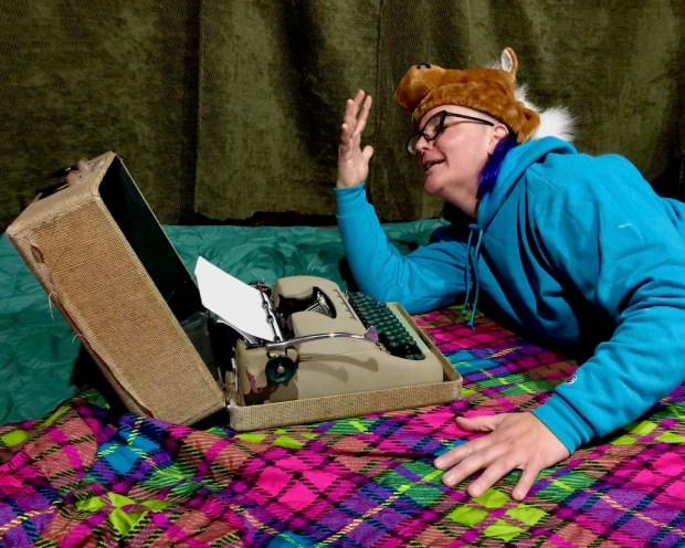 playwright Teresa Martuccio feigning exasperation while writing on a manual typewriter