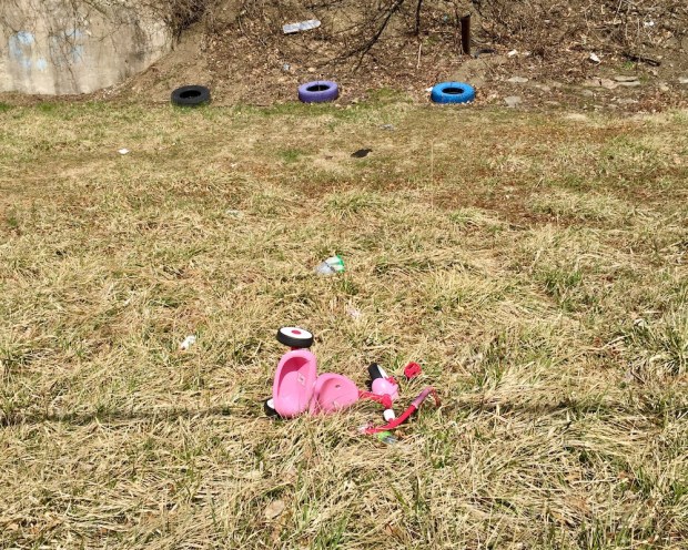 pink tricycle abandoned in grassy lot