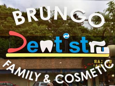 logo for Brungo Dentistry including colorful letters made to look like teeth, toothpaste, and a toothbrush
