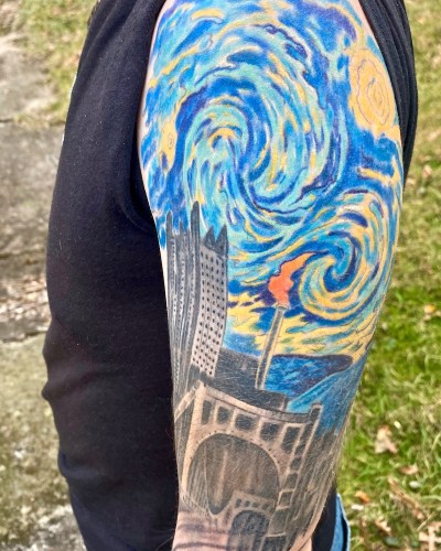 Monessen mayor Matt Shorraw's tattooed arm including image combining downtown Pittsburgh with flaming smokestack of Monessen
