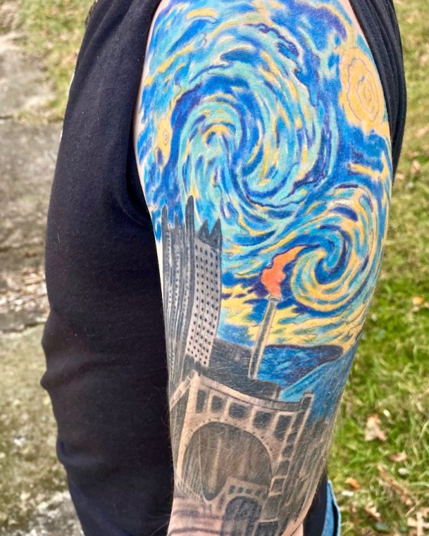 Monessen mayor Matt Shorraw's tattooed arm including image combining downtown Pittsburgh with flaming smokestack of Monessen