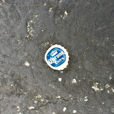 bottle cap embedded in road tar
