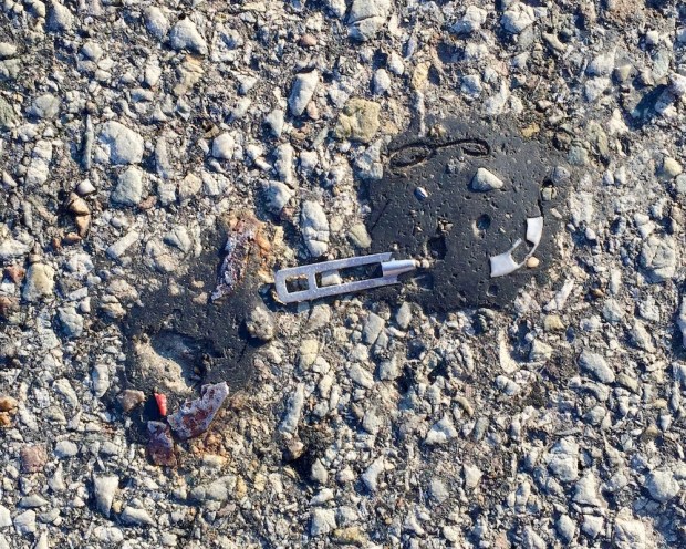 zipper pull embedded in road tar