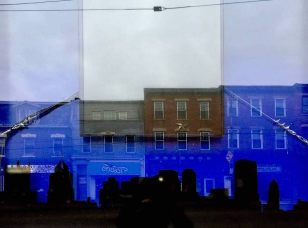 tavern window with reflection of city buildings above a skyline silhouette of downtown Pittsburgh