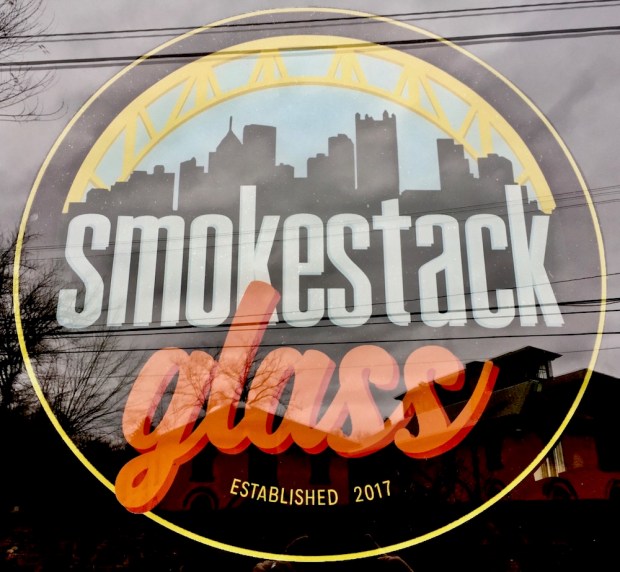 window sign for Smokestack Glass including the Pittsburgh skyline