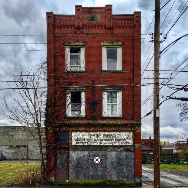 older brick commercial building with red "X" for demolition, New Kensington, PA