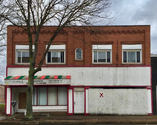 older brick commercial building with red "X" for demolition, New Kensington, PA