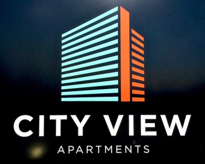 signage for City View Apartments featuring simplified graphic version of the building's shape