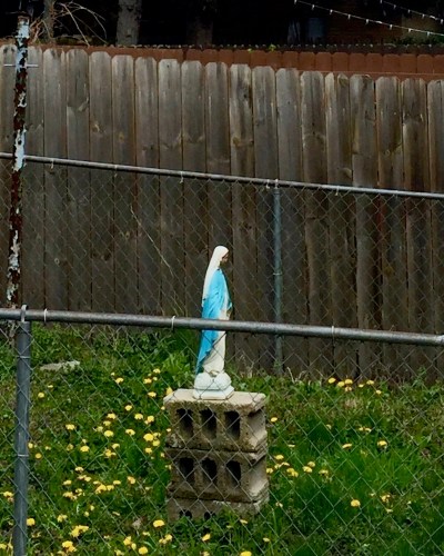 statue of Mary on cinderblocks in backyard