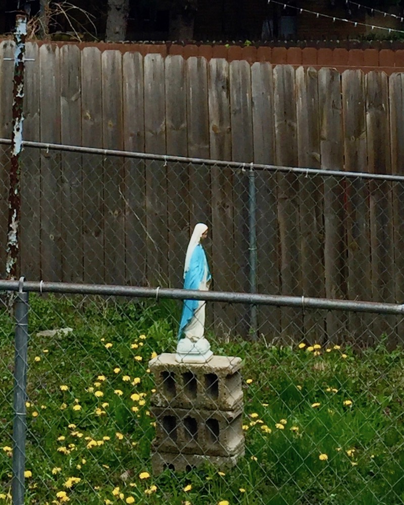 statue of Mary on cinderblocks in backyard
