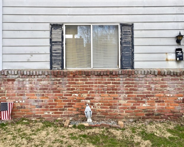 statue of Mary leaning against house