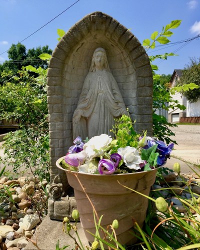 statue of Mary and flowers in pot