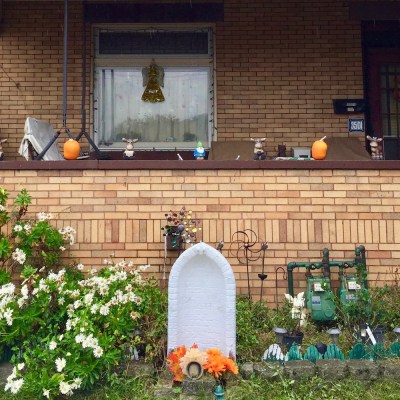 empty Mary grotto in front of brick house