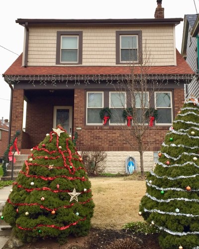 statue of Mary in front of house with Christmas decorations