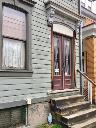 house with small statuette of Mary by front steps