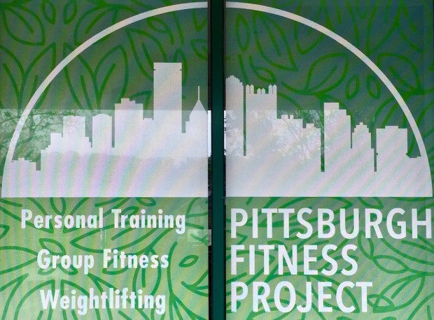 printed sign for Pittsburgh Fitness Project gym including image of the downtown skyline