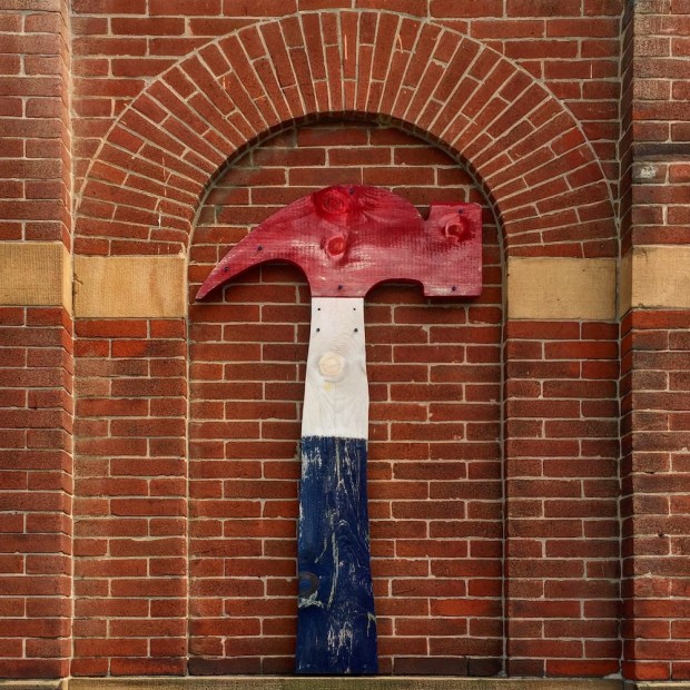 artwork shaped like large claw hammer painted in red, white, and blue