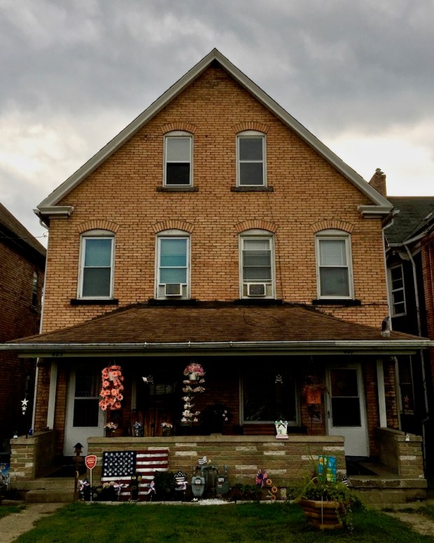 brick residential house with prominent American flag decoration