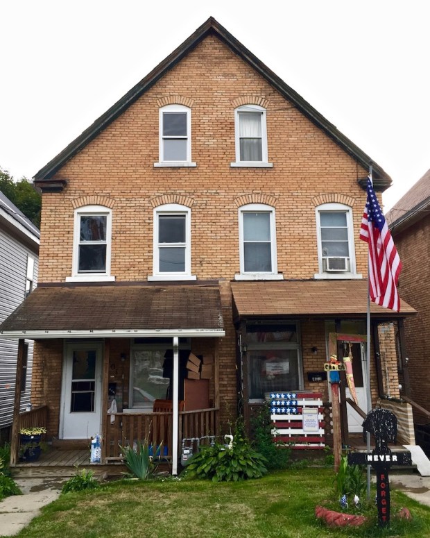 brick residential house with prominent American flag decoration