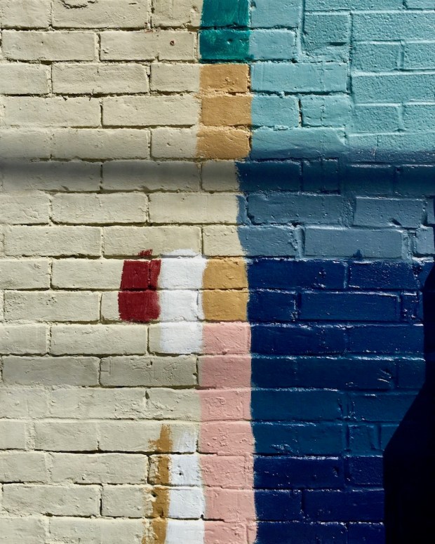 brick wall with many colors of paint tested