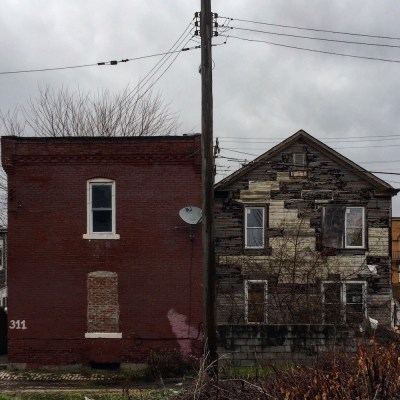 brick row house with flat roof next to wooden row house with peaked roof, McKees Rocks, PA