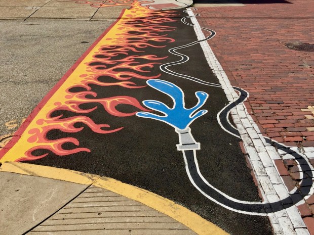 street crosswalk mural of fire and water hose