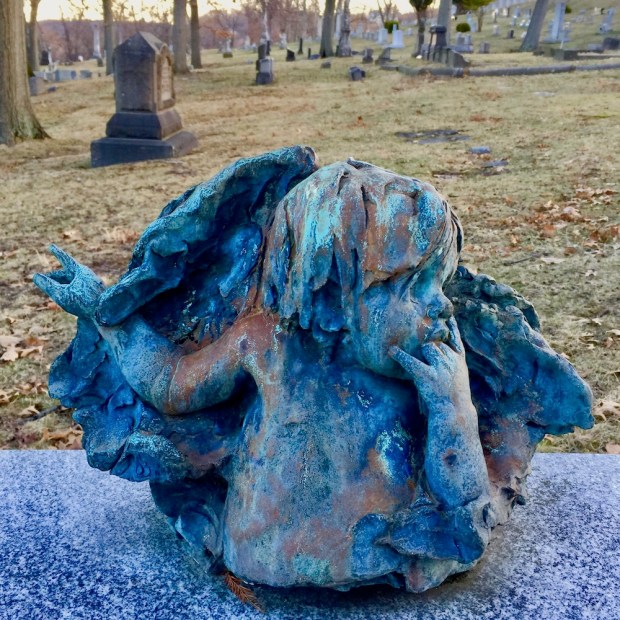 handmade grave sculpture of young boy's head and torso