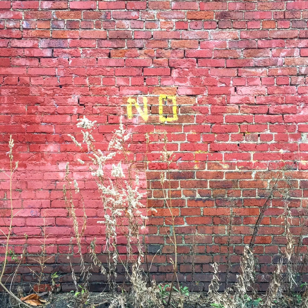 brick wall with word "No" painted on it