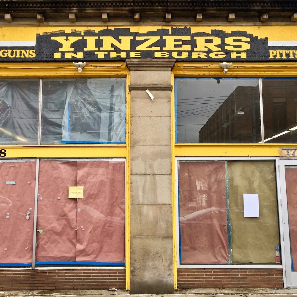 closed storefront of Yinzers in the Burgh with hand-painted Pittsburgh skyline