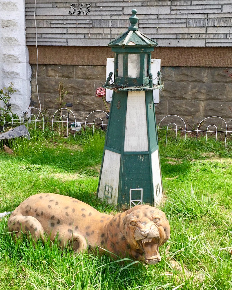lighthouse lawn ornament with leopard model in front yard of house