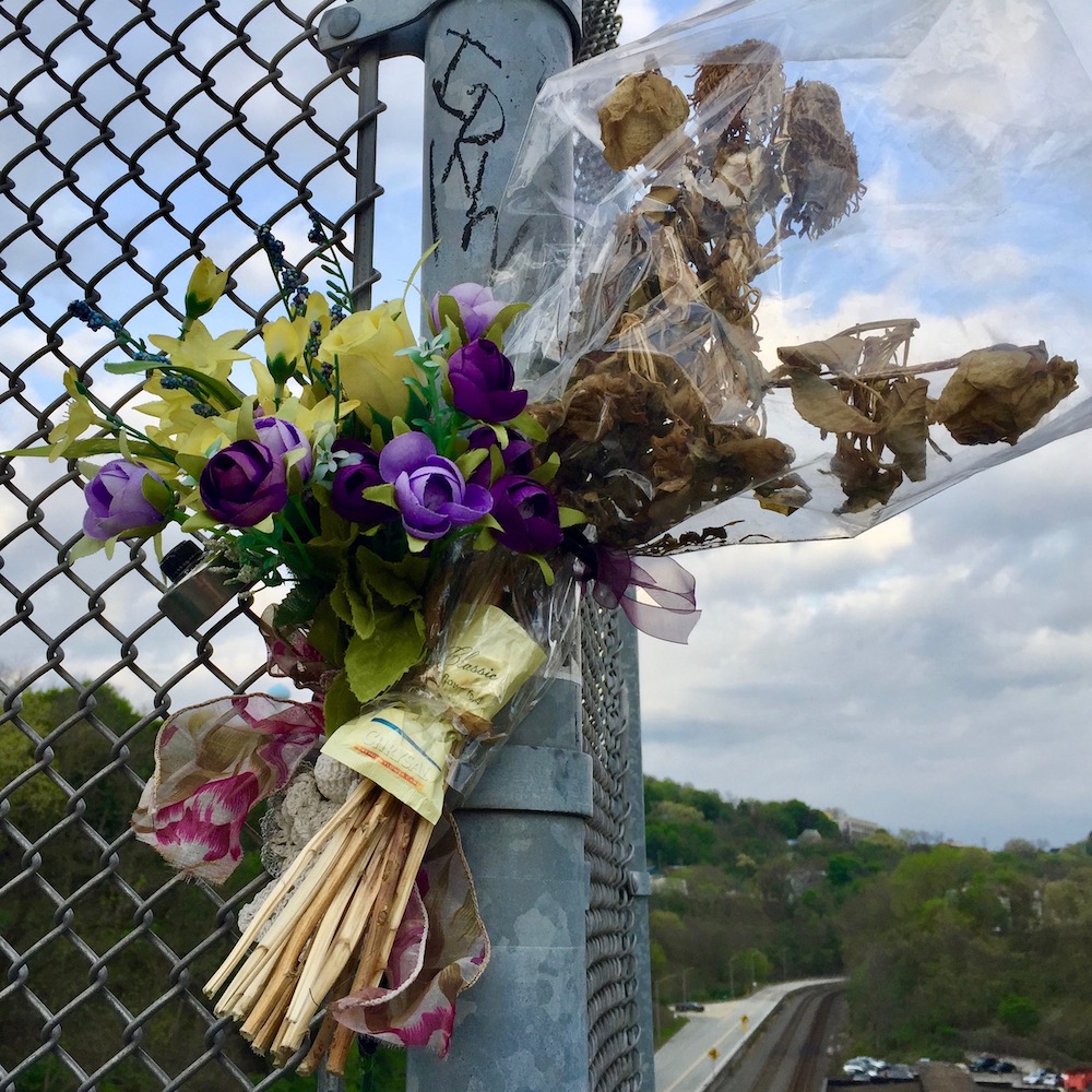 memorial flowers in chain link fence