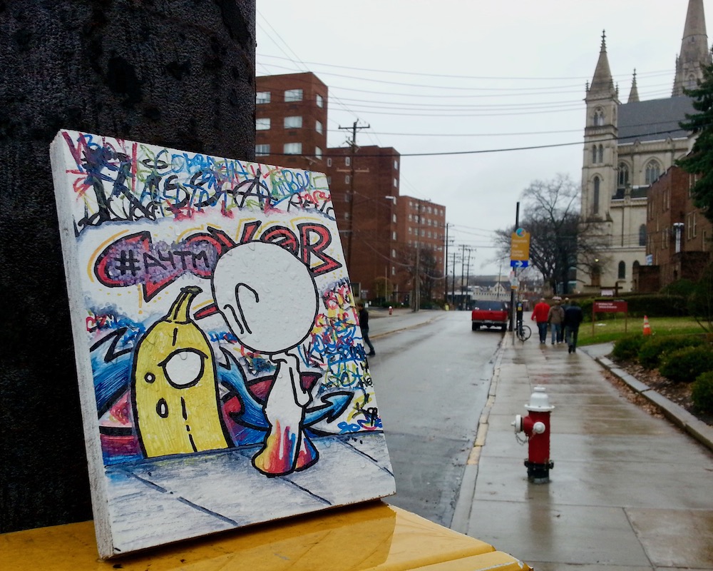 painting of cartoon banana and alien left outside on newspaper box