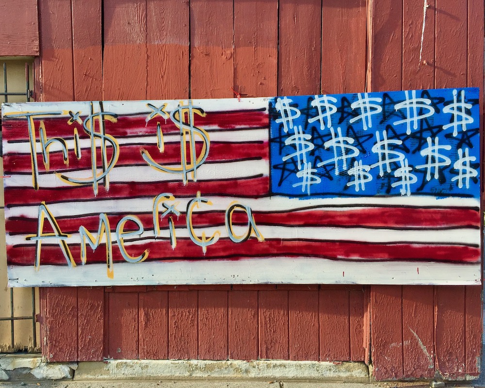 painting of American flag with dollar signs for stars