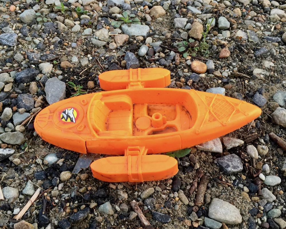 plastic toy boat crushed in gravel
