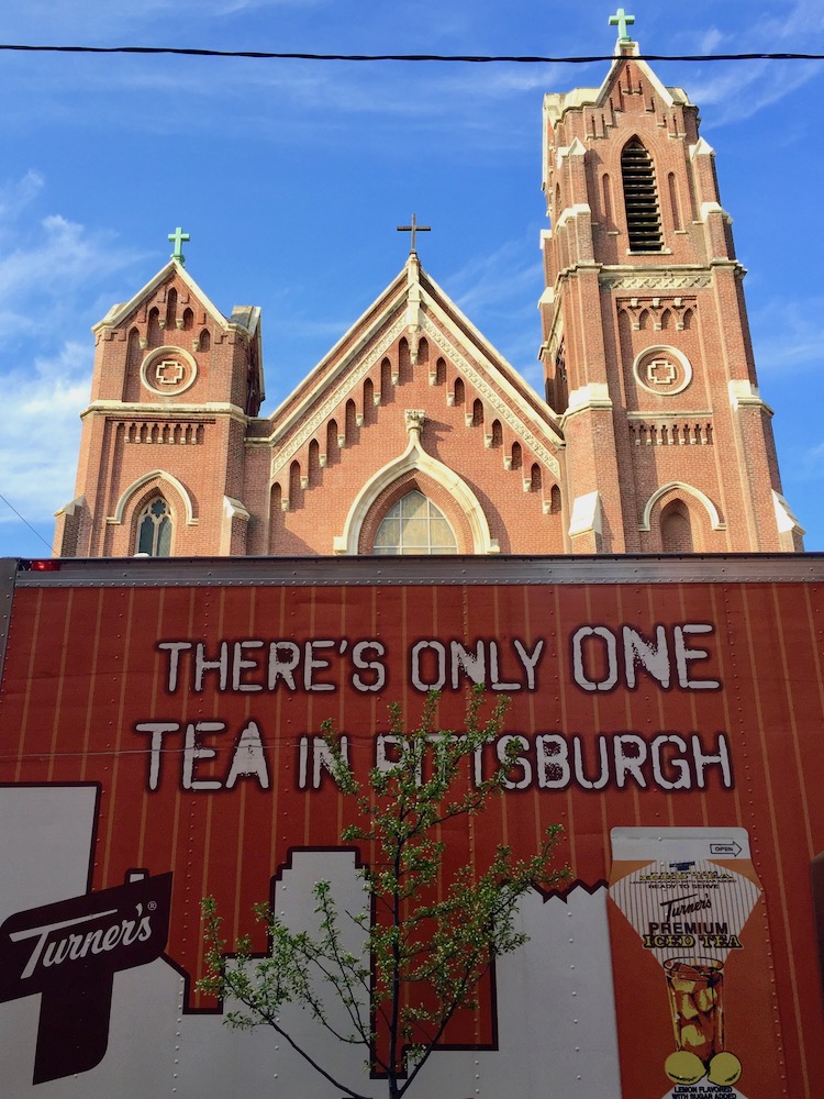 Turner's Tea van with graphics of the Pittsburgh skyline parked in front of ornate church