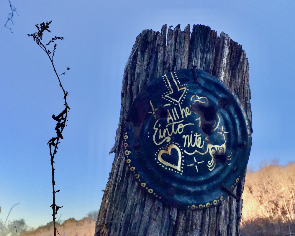 painting on tin can nailed to utility pole