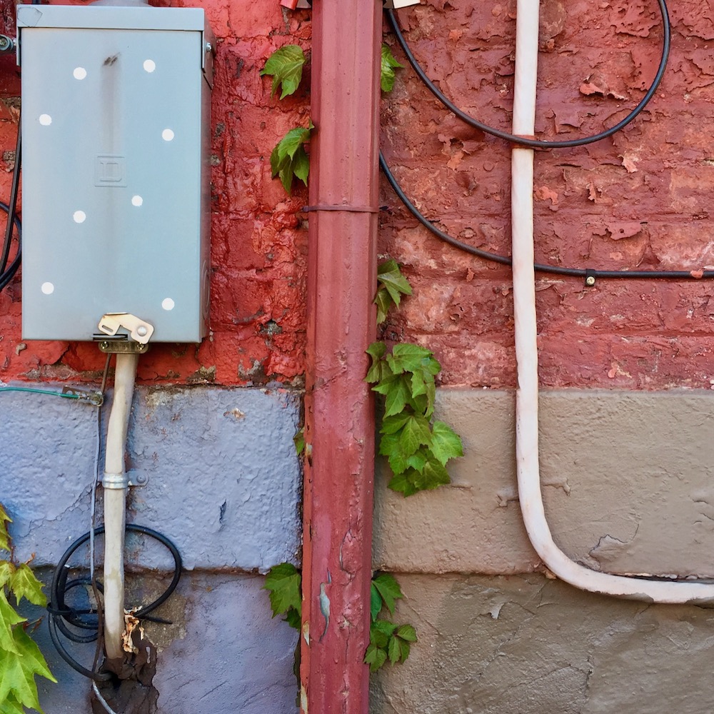 detail of painted row house walls and foundation showing distinct square quarters of different shapes and colors