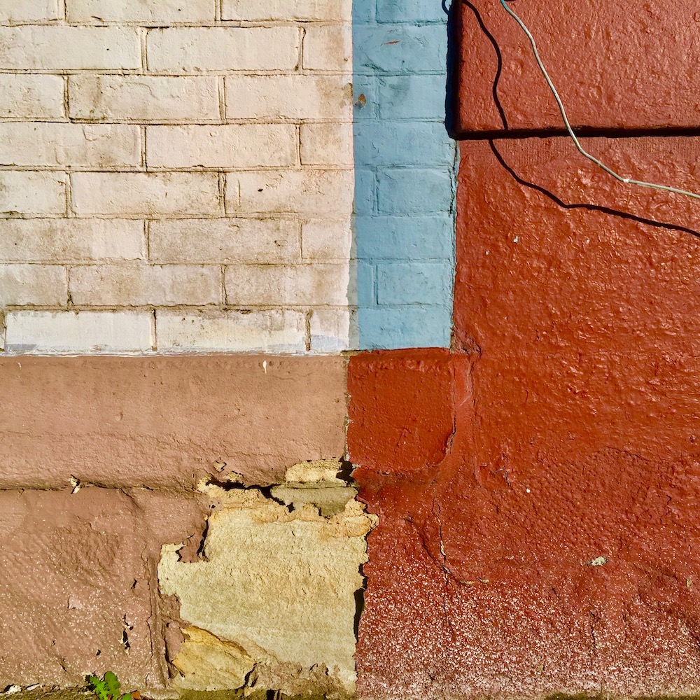 brick exterior wall of row house painted in multiple sections