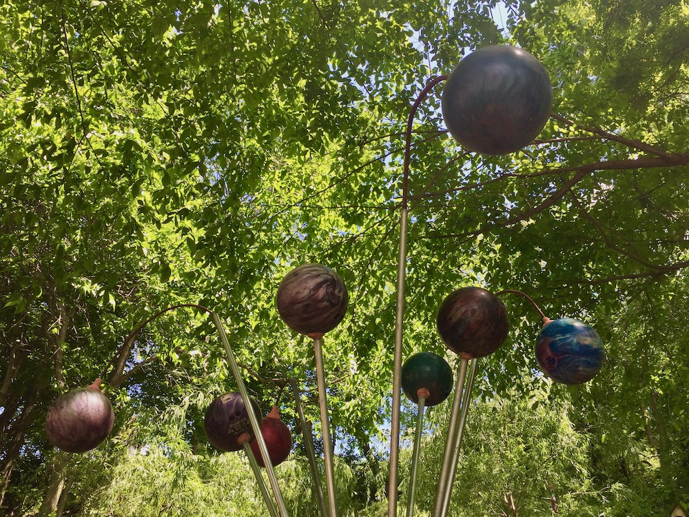 sculpture with many bowling balls on long rods